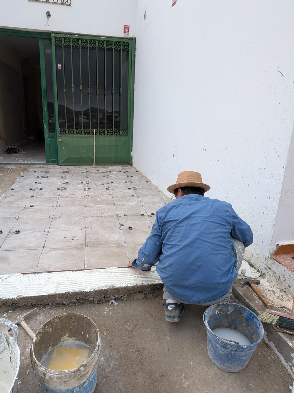 Colocación del pavimento cerámico del patio, con las piezas replanteadas y crucetas de nivelación