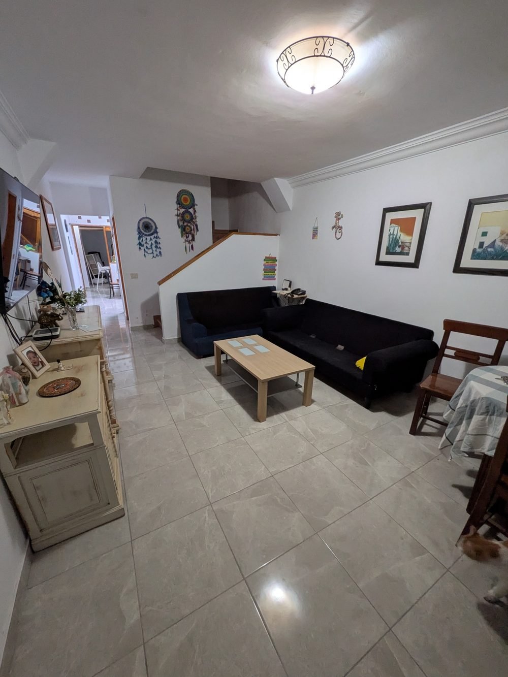 El mismo salón después de la reforma, con la cerámica nueva colocada sobre el suelo antiguo y las paredes pintadas
