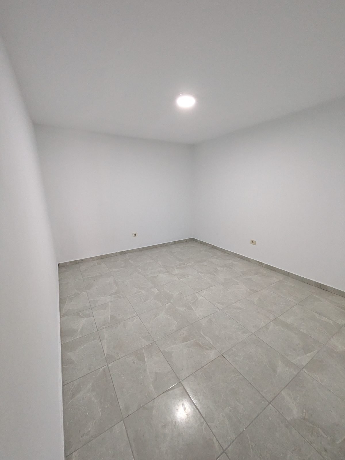 Salón terminado tras una reforma completa de vivienda en Lanzarote, con pavimento porcelánico nuevo